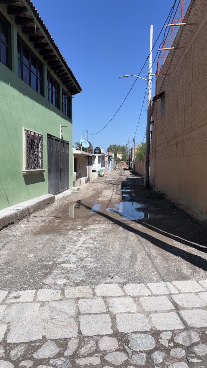 Narrow street with a green house in San Miguel de Allende, Mexico